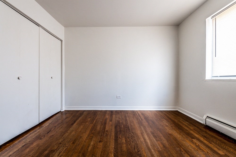 an empty room with wooden floors and white walls