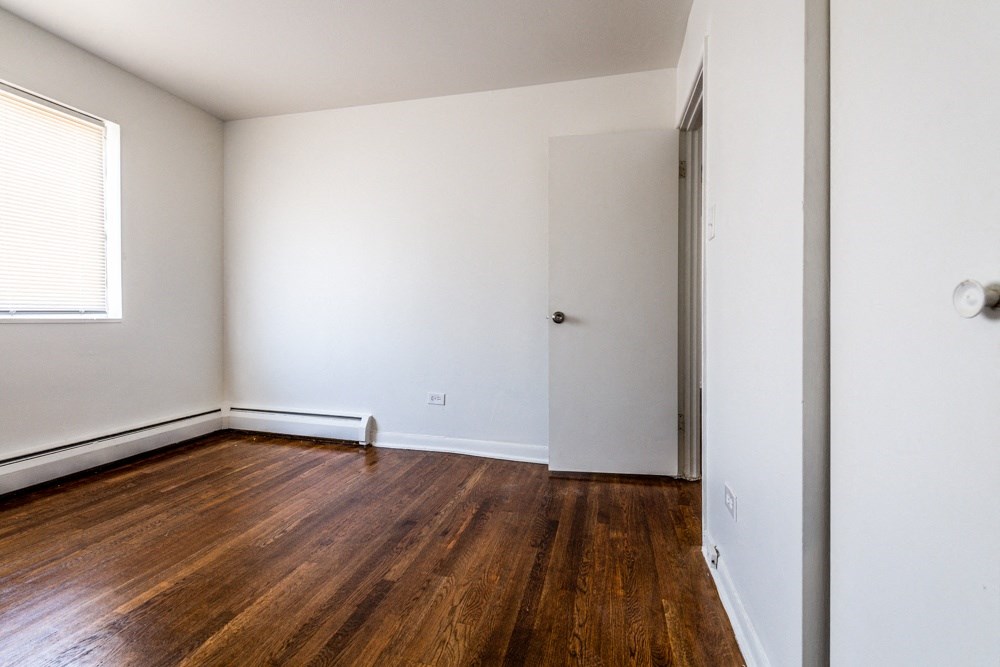 an empty room with wooden floors and white walls