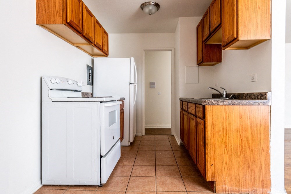 a kitchen with a white refrigerator and a sink
