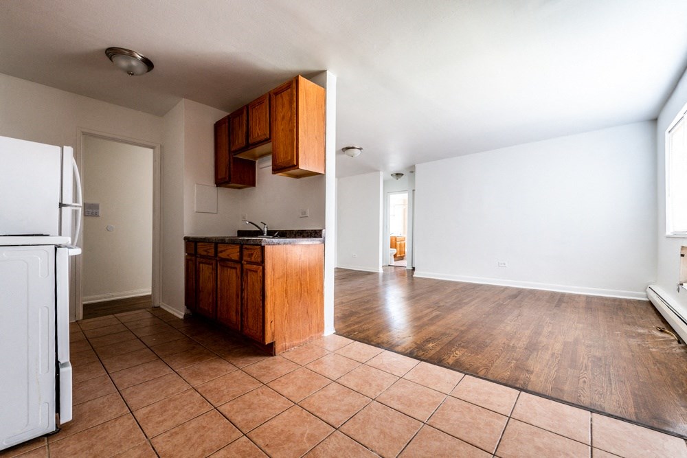an empty kitchen and living room with white walls and wood floors