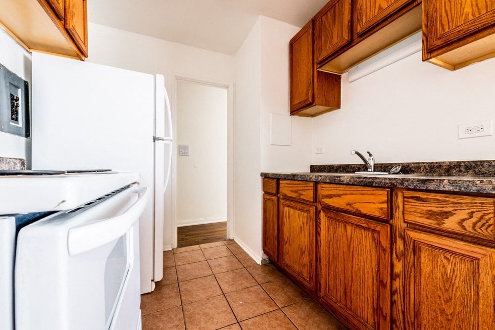 a kitchen with white appliances and wooden cabinets