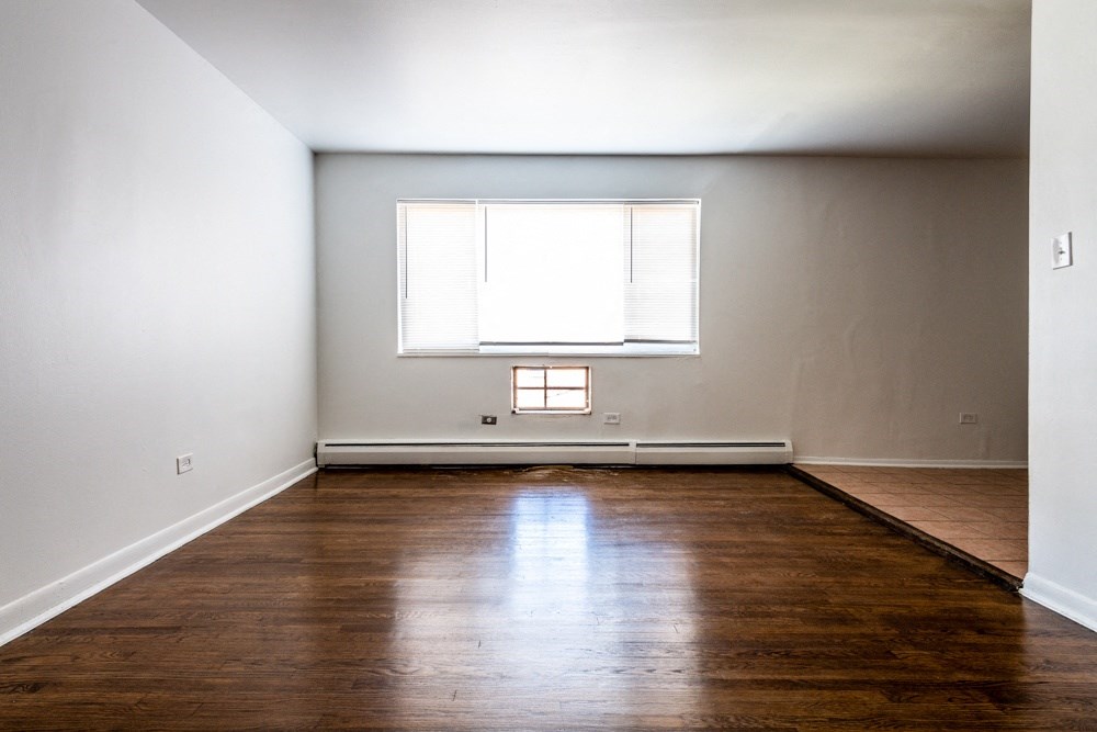 an empty room with wooden floors and a window