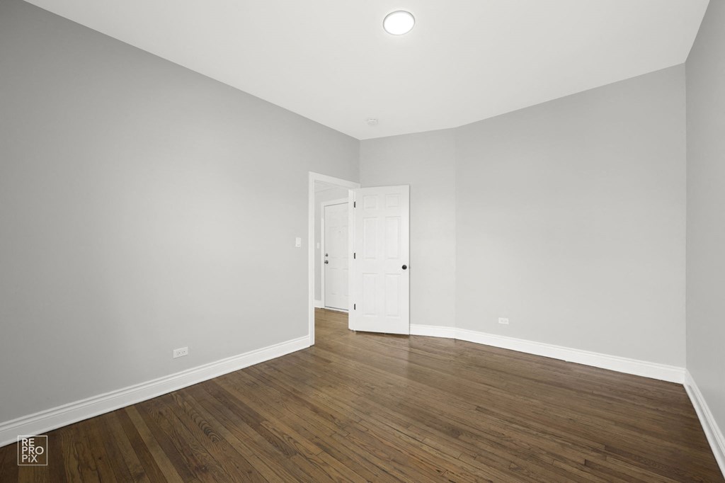 a renovated living room with white walls and wood floors