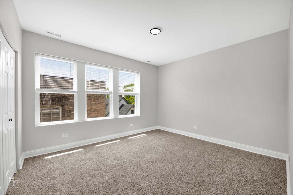 a bedroom with gray walls and carpet