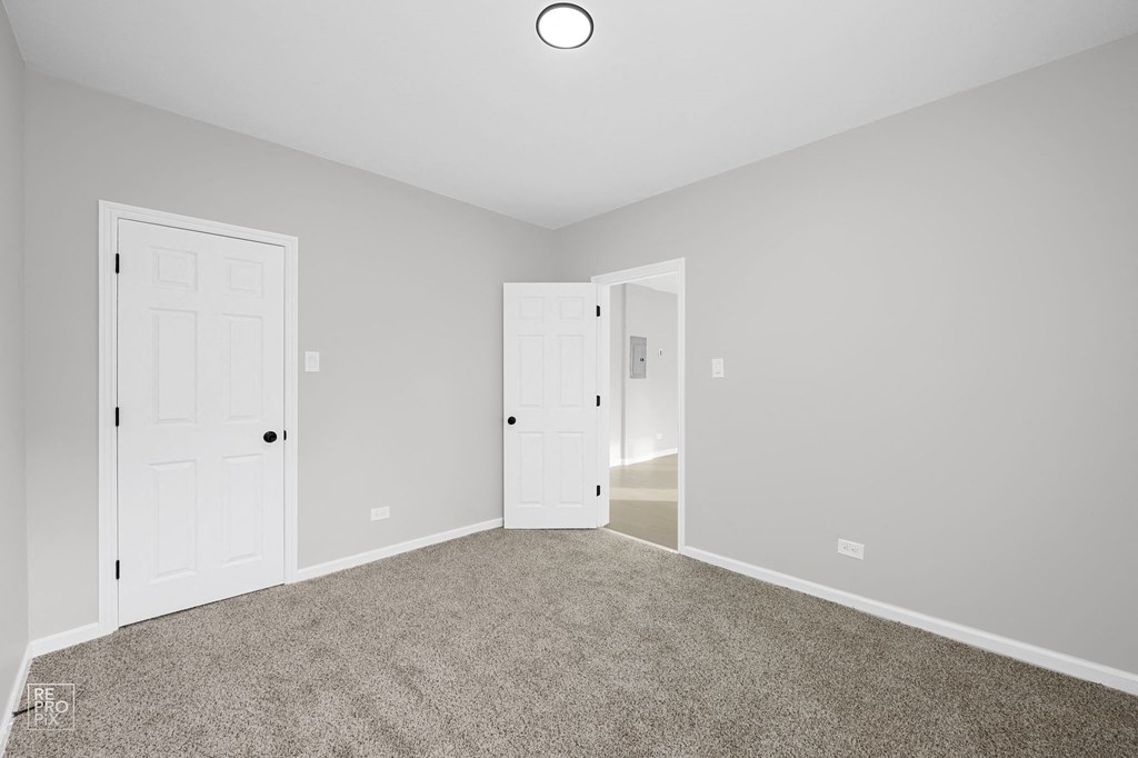 a bedroom with two doors and a carpeted floor