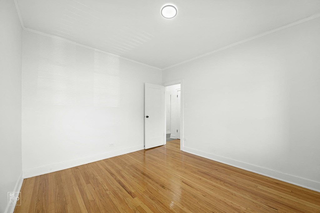a living room with white walls and wood floors