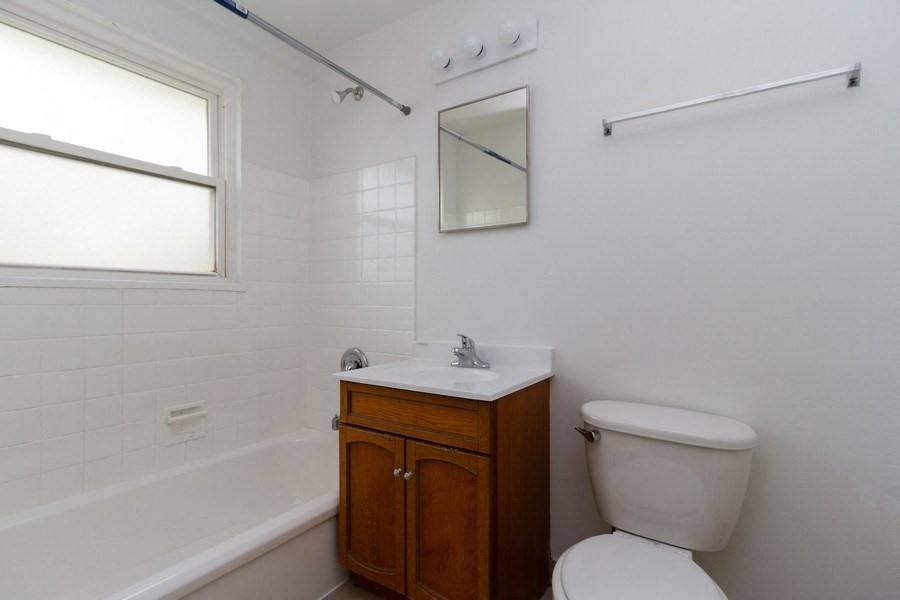 a white bathroom with a toilet and a sink