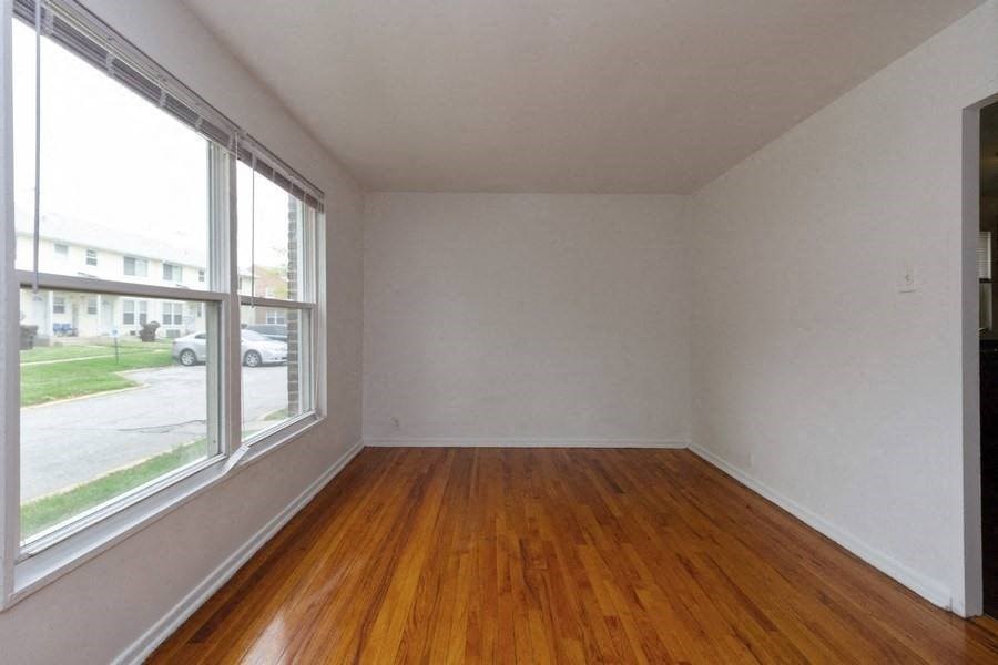 an empty room with a wood floor and a large window