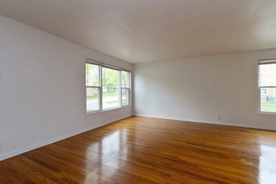 an empty living room with white walls and wood floors