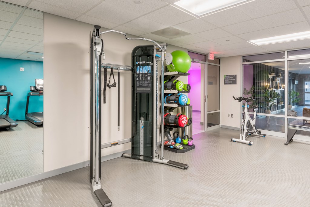 a gym with weights and equipment in the corner of a room