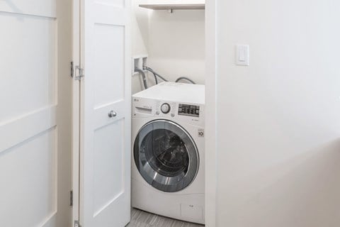 a white washer and dryer in a white laundry room