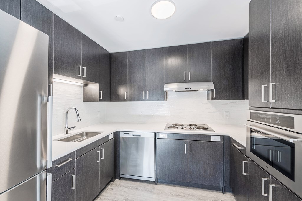a kitchen with black cabinets and stainless steel appliances