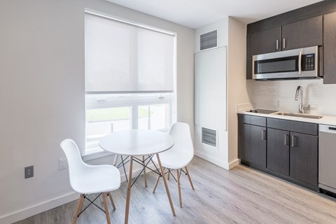 a kitchen with a table and chairs and a microwave