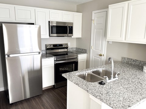 a kitchen with granite counter tops and stainless steel appliances