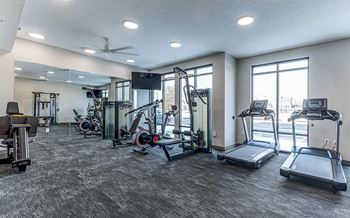 A spacious gym with treadmills, weights, and exercise equipment.