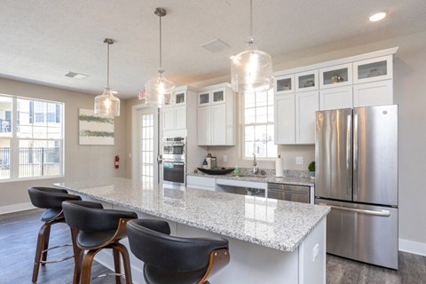 a kitchen with a marble counter top and a stainless steel refrigerator