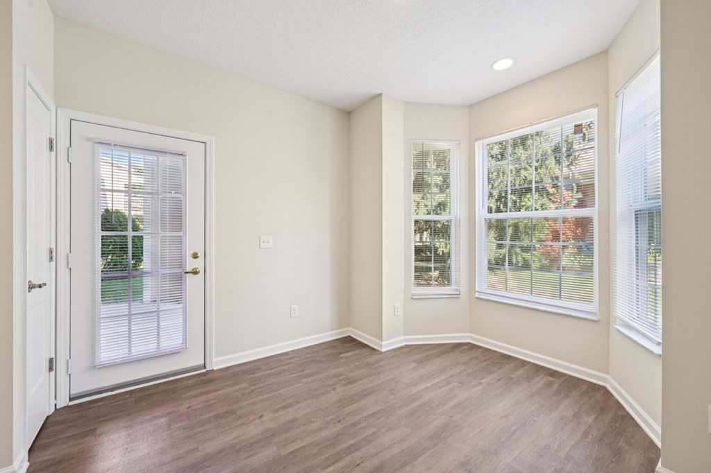 A room with a white door and two windows with white frames.