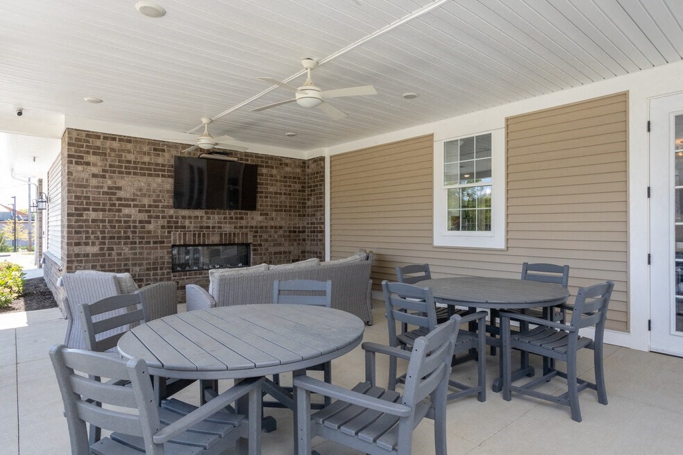 a patio with a table and chairs and a fireplace