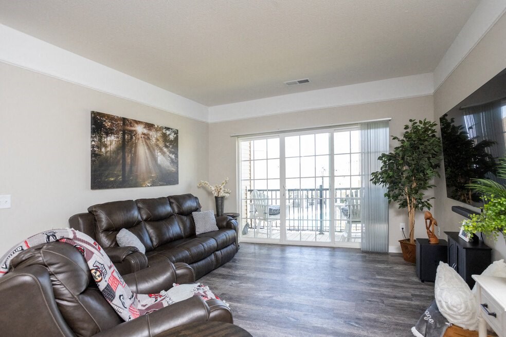 a living room with leather furniture and a sliding glass door