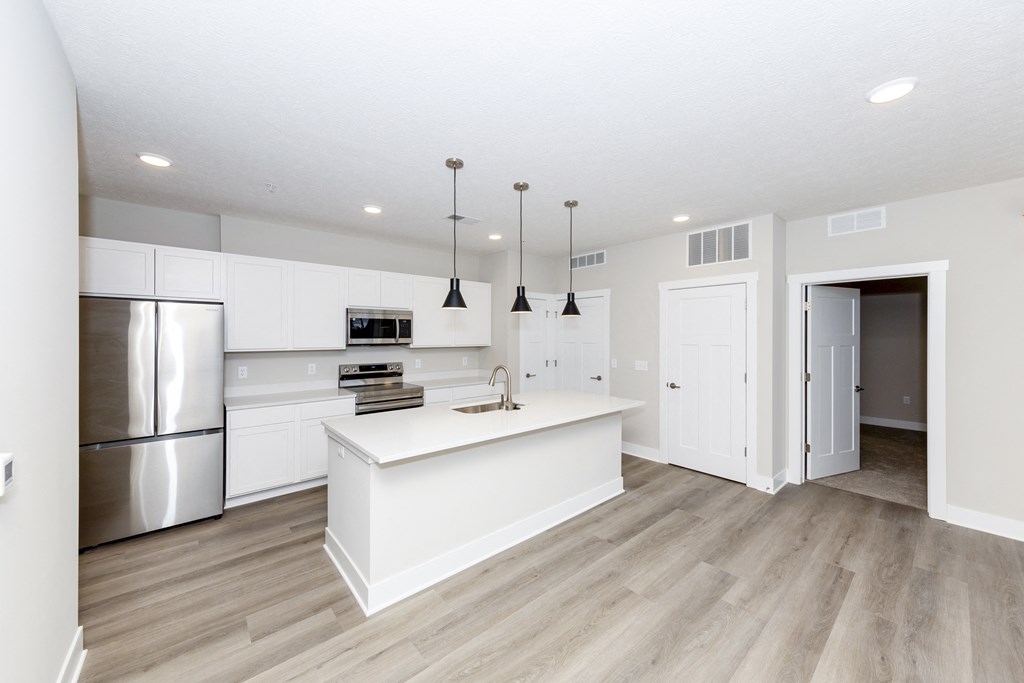 A kitchen with a white island and stainless steel appliances.at Tiffany Flats, Columbus, Ohio