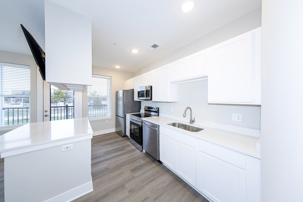 A modern kitchen with white cabinets and stainless steel appliances.at Tiffany Flats, Ohio, 43231