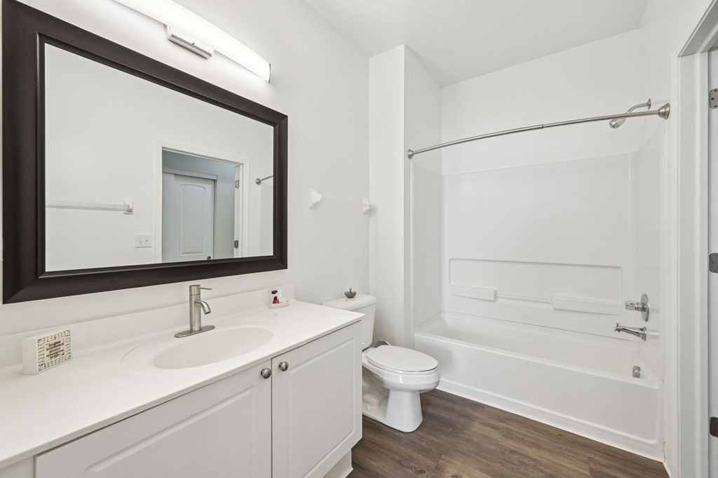 A white bathroom with a toilet, sink, and bathtub.