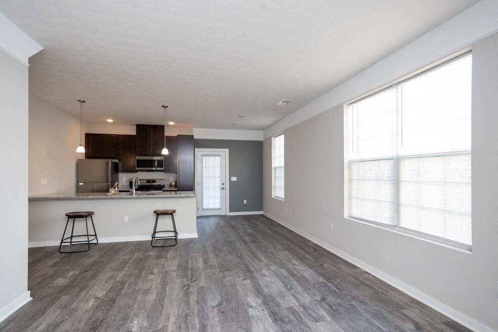 the living room and kitchen of an apartment with a large window