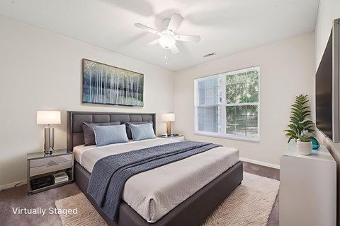 A bedroom with a bed, nightstands, and a painting on the wall.