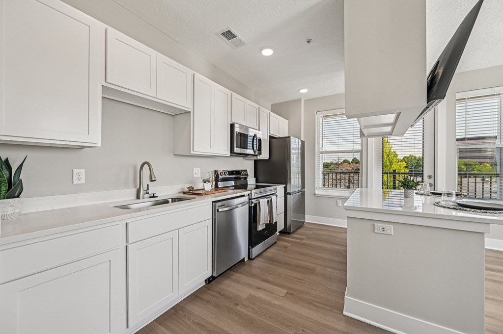 A modern kitchen with white cabinets and stainless steel appliances.