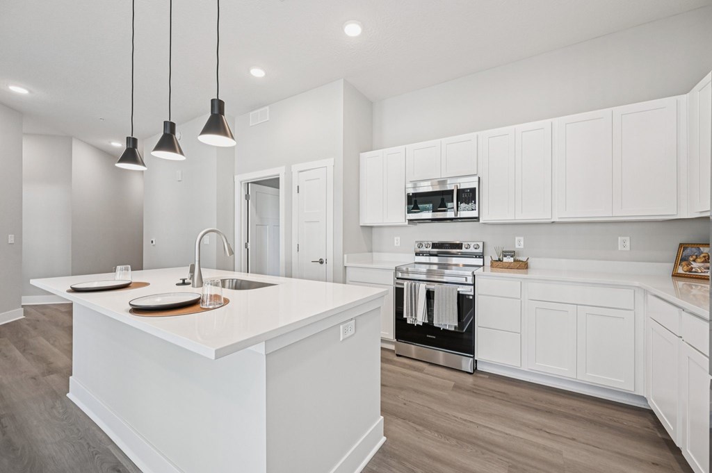 A modern kitchen with white cabinets and a central island.