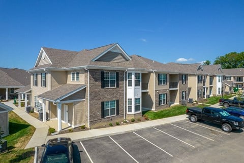 an apartment building with cars parked in a parking lot