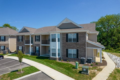 an apartment building with a sidewalk in front of it