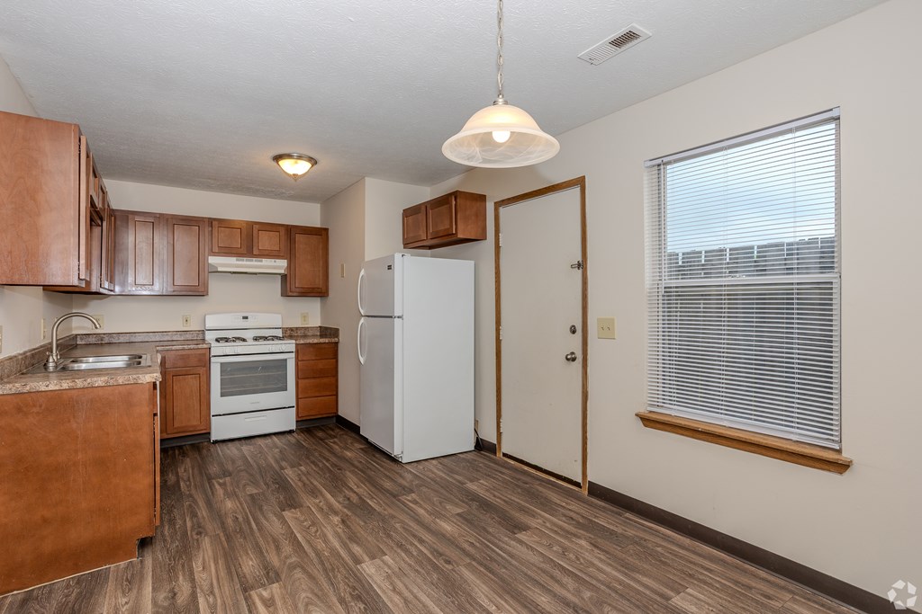 A kitchen with wooden cabinets and a white refrigerator.