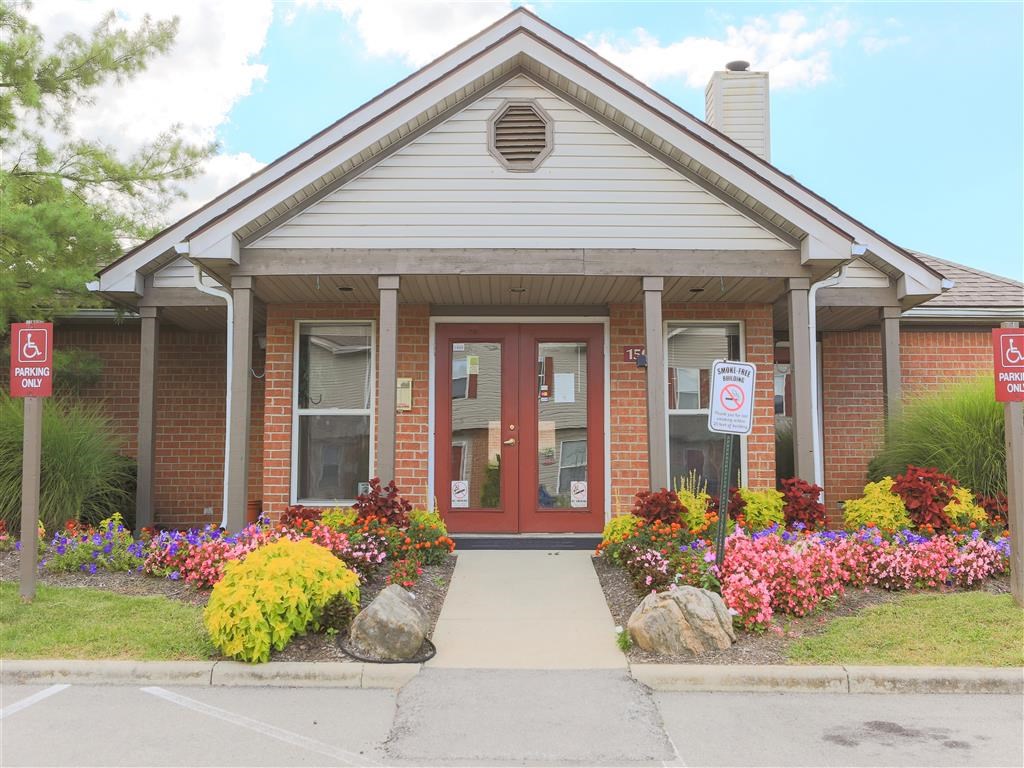 the front of a building with a red door and a sidewalk in front of it