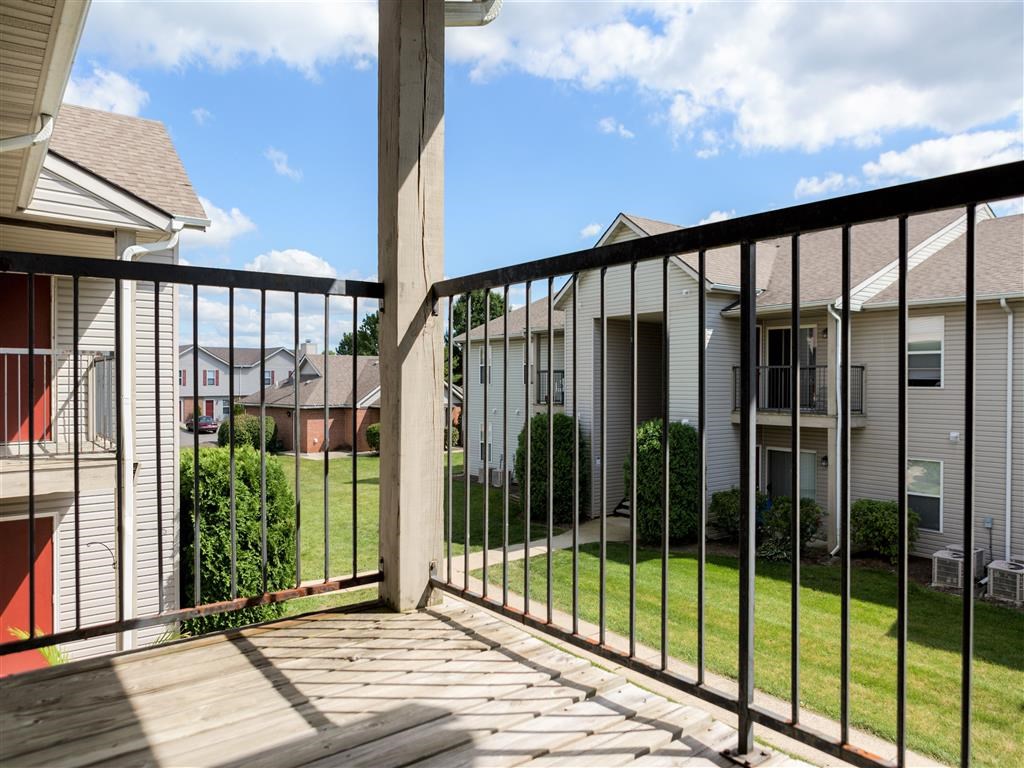 a balcony with a view of a yard and houses