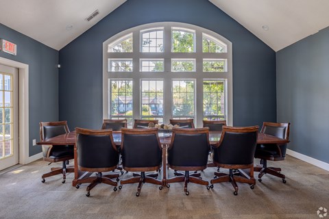 A conference room with a large table and chairs.