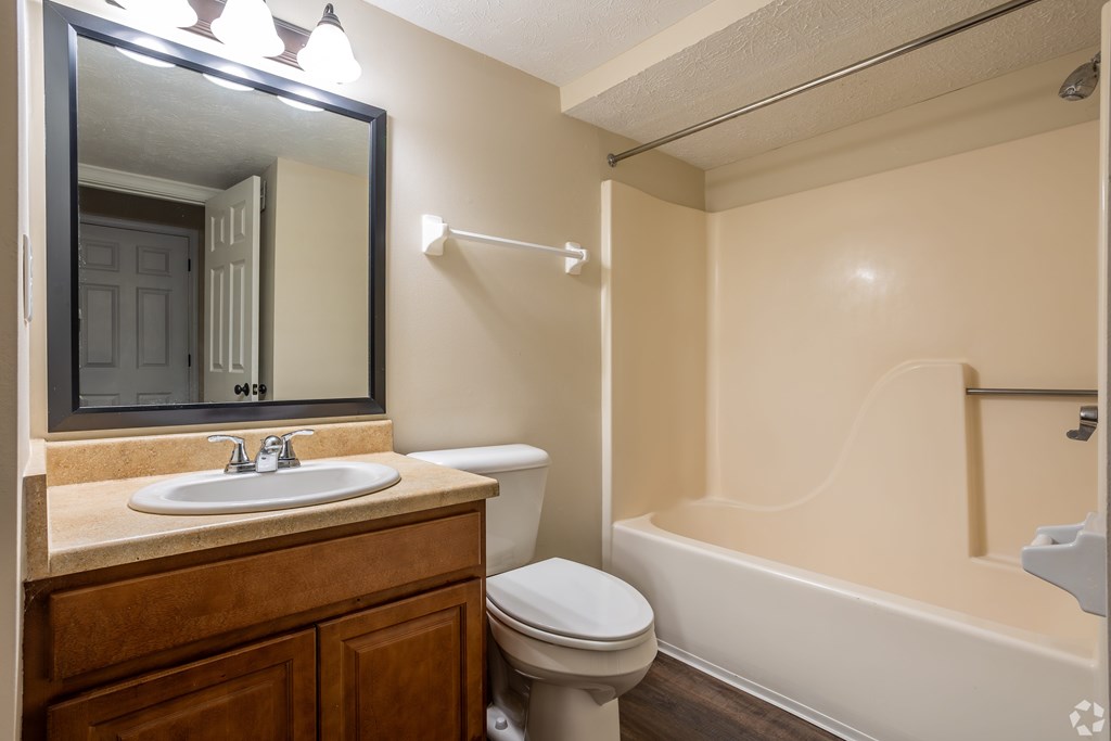 A bathroom with a toilet, sink, and bathtub.
