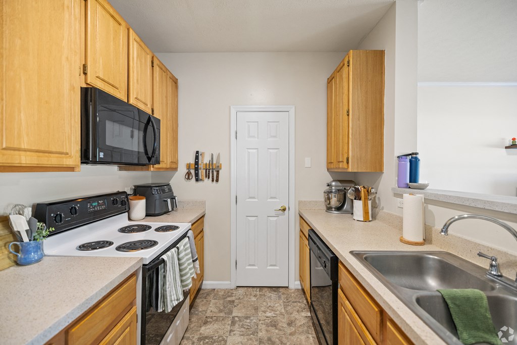 a kitchen with a sink and stove and a door