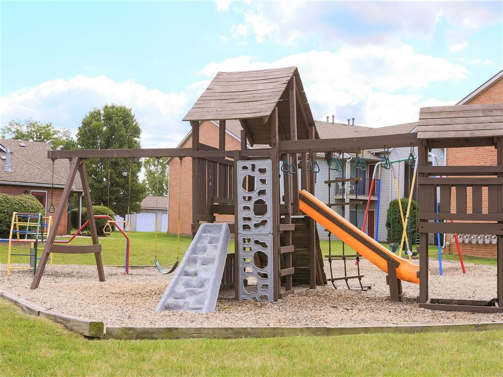 a childrens play area with a swing set and a slide
