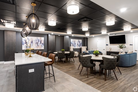 A modern dining area with a white counter and brown chairs.
