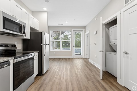 A kitchen with black appliances and white cabinets.