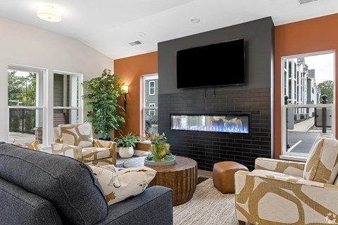 A living room with a grey couch, a black TV, and a fireplace.