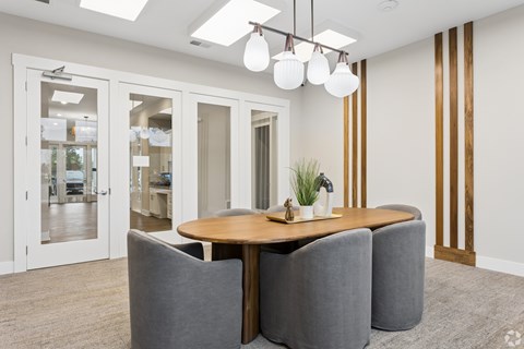 A modern dining room with a wooden table and grey chairs.