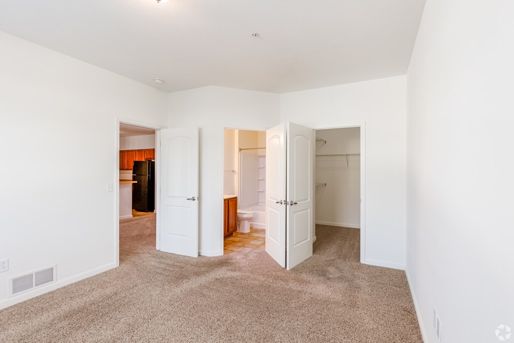 A large, empty room with carpeted floors and white walls.