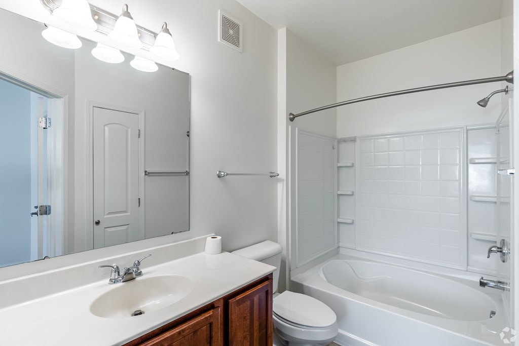 A white bathroom with a sink, toilet, and bathtub.
