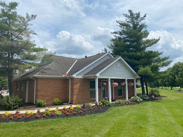 a small brick house with a yard and trees