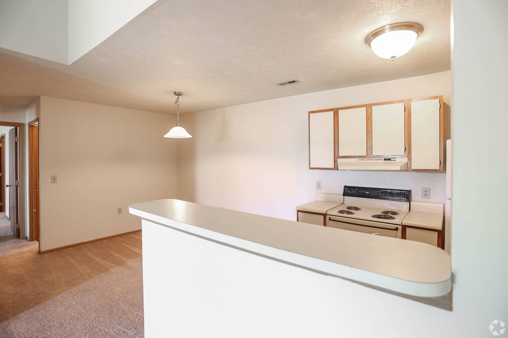 A white reception desk in a room with a cabinet and a microwave.