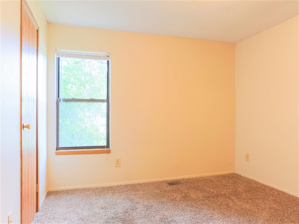 an empty room with a window and carpet