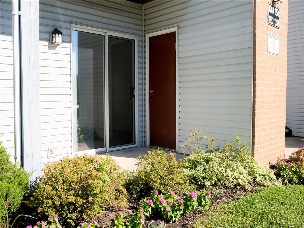 a front porch of a house with a red door
