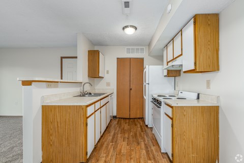 A kitchen with wooden cabinets and a white counter.